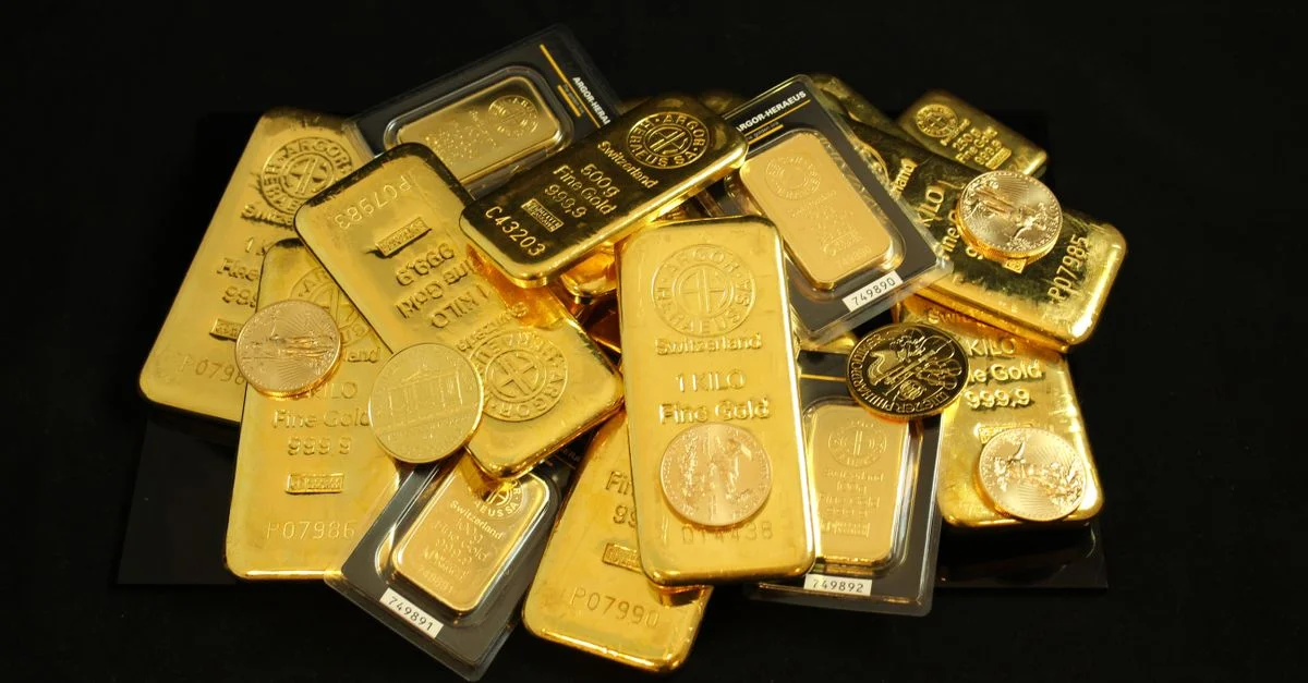 Une collection de lingots d'or et de pièces symbolisant la richesse et l'investissement.