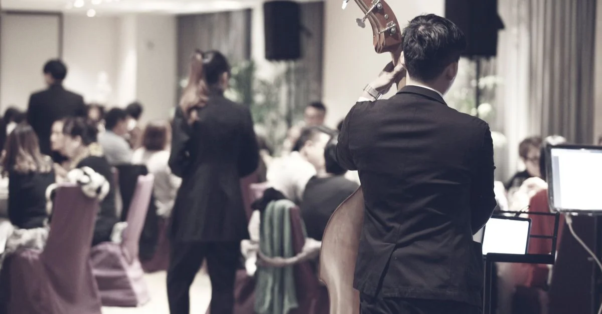 Un événement dîner dynamique à Taipei avec une performance musicale en direct d'un joueur de contrebasse.