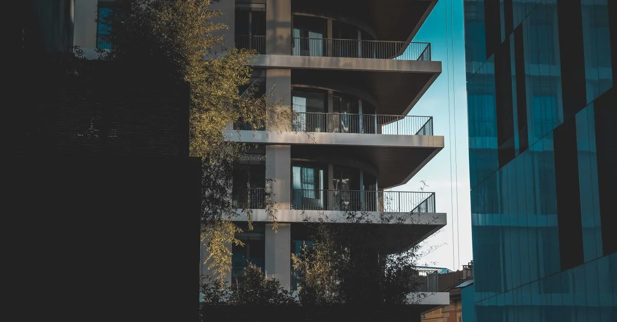 Immeuble résidentiel contemporain à plusieurs étages avec balcons et design moderne dans un cadre urbain.