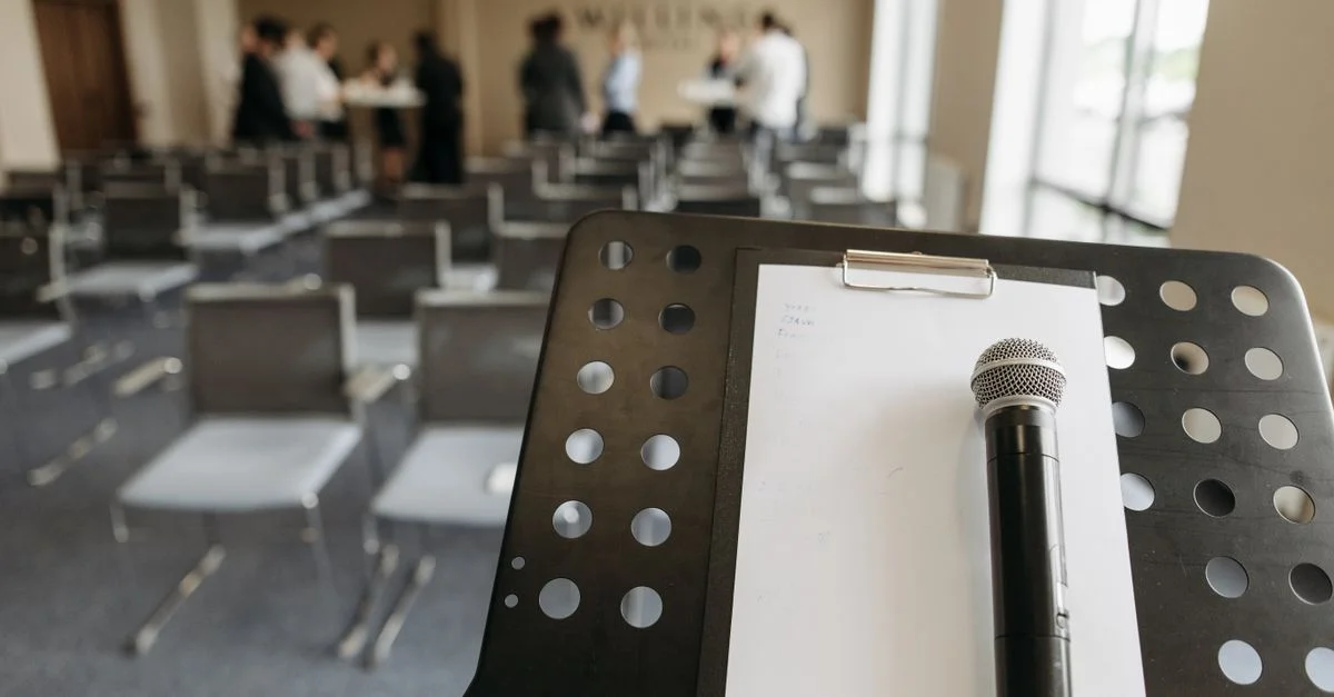 Gros plan d'un microphone sur un podium dans un cadre de salle de conférence.